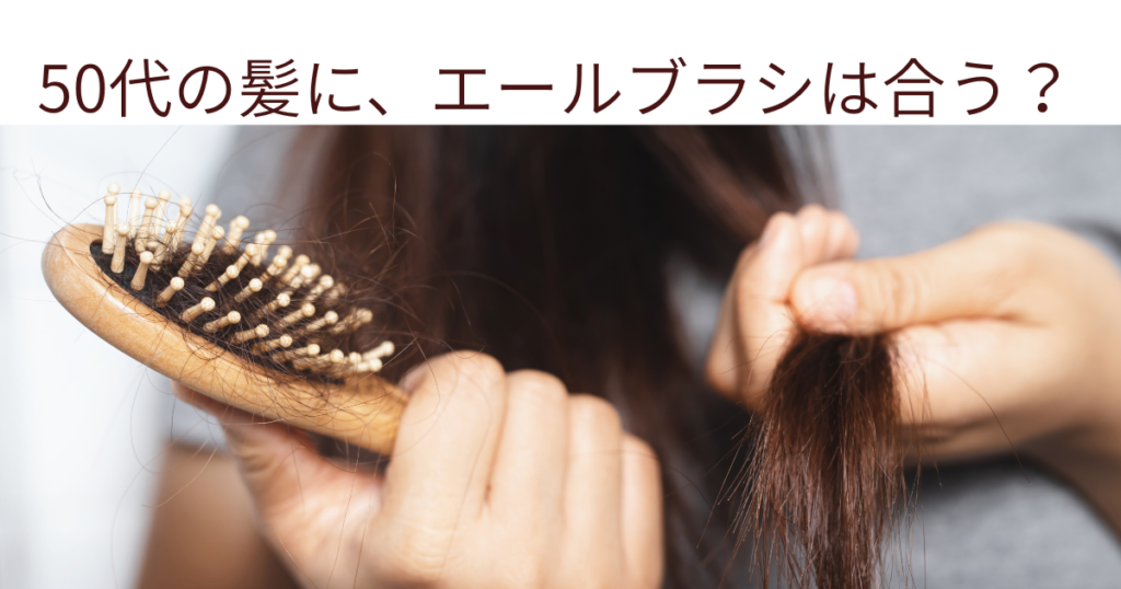 50代の髪をブラシでとかす手元